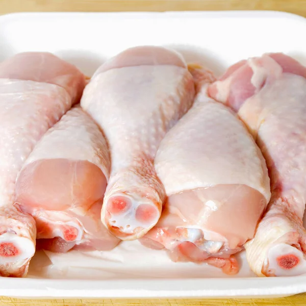 焼きたての鶏の肉のドラムスティック作品 調理する準備ができてパッケージバッグで まな板に — ストック写真