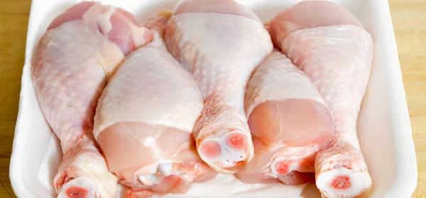 焼きたての鶏の肉のドラムスティック作品 調理する準備ができてパッケージバッグで まな板に — ストック写真
