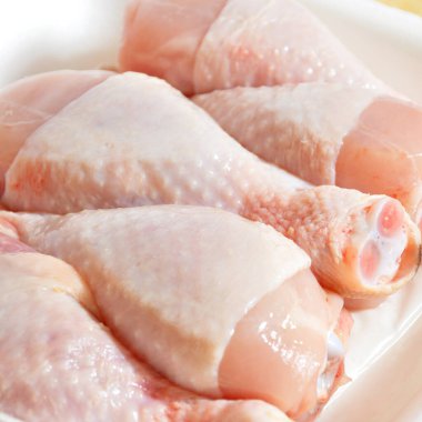 Taze pişmemiş tavuk budu parçaları, pişmeye hazır bebek, kesme tahtasında.