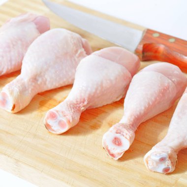 Taze pişmemiş tavuk eti parçaları ve bıçak, pişirmeye hazır bebek, kesme tahtasında.