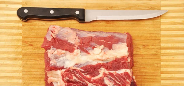 Clean very fresh red raw cow meat beef sharp knife, bamboo on cutting board, cow meat texture