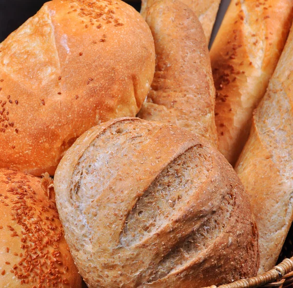 新鲜烘焙的营养丰富的金色面包自制 装在柳条篮里 — 图库照片
