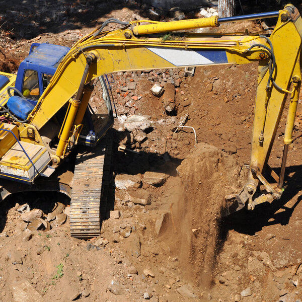 Экскаватор продолжает работу на строительной площадке, на раскопках и экскаваторе 