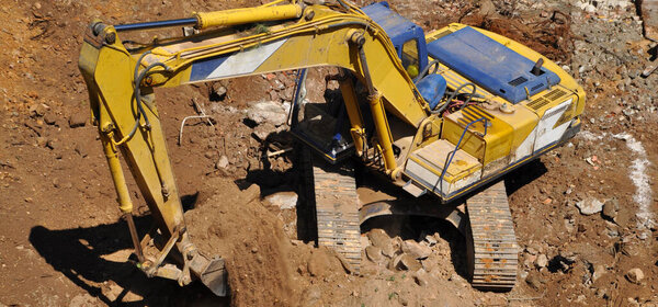 Экскаватор продолжает работу на строительной площадке, на раскопках и экскаваторе 