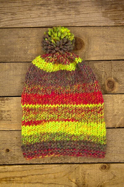 木制背景的手工毛织冬季彩帽 — 图库照片
