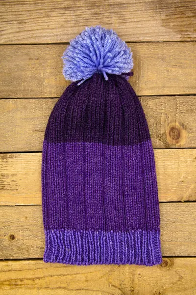 木制背景的手工毛织冬季蓝帽子 — 图库照片