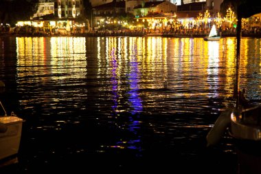 İnsanlar, 28 Haziran 2023 'te Datca, Türkiye Mugla Datca şehir merkezindeki gece plaj restoranlarında yemek yiyip eğleniyorlar.