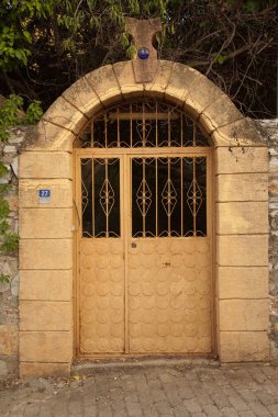 Datca ya da Eski Datca, Mugla Turkey 'deki nostaljik evin dekoratif demir metal bej kapısı, 29 Haziran 2023