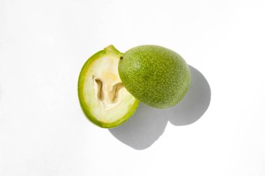 Olgunlaşmamış cevizlerin yeşil dış kabukları ikiye bölünmüş, olgunlaşmamış yeşil cevizler.