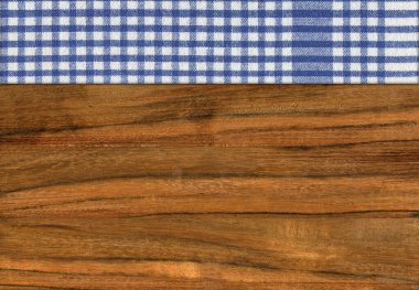 Ceviz ağacından yapılmış, mavi beyaz bir peçete boş bir masa ya da kesme tahtası.