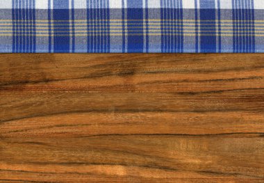 Ceviz ağacından yapılmış, mavi beyaz bir peçete boş bir masa ya da kesme tahtası.