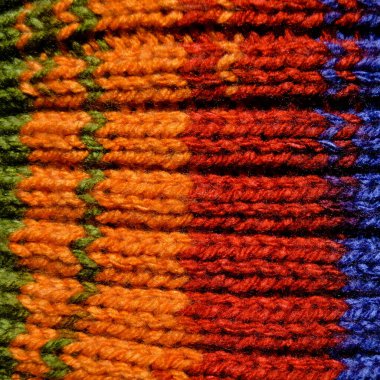Yünden desenli kumaş. El yapımı, kırmızı, mavi ve turuncu yün arka plan dokusu.