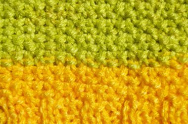 Pattern fabric made of wool. Handmade knitted fabric green and yellow wool background texture