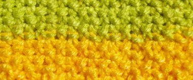 Pattern fabric made of wool. Handmade knitted fabric green and yellow wool background texture