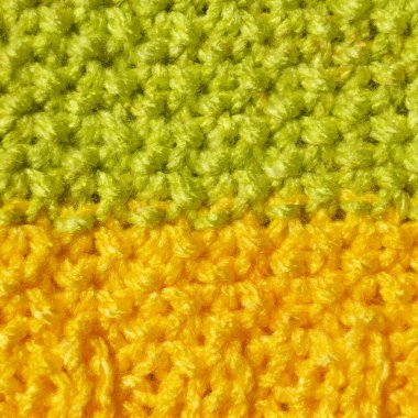 Pattern fabric made of wool. Handmade knitted fabric green and yellow wool background texture