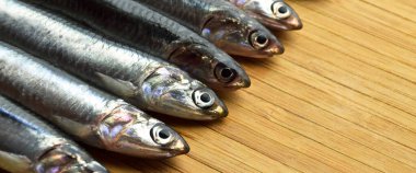 Temizlenmiş ve pişmeye hazır taze balık hamsi, kesme tahtasında ançüez konsepti