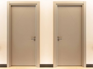 Modern gri ön giriş. Ahşap iki kapı. Evin içinde şık bir tasarım var.