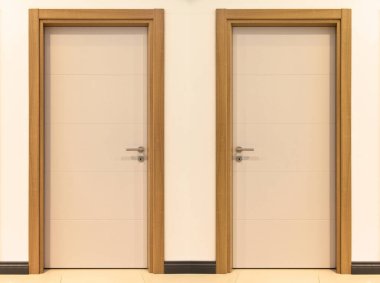 Modern kahverengi ve beyaz ön giriş ahşap iki kapı evin içinde şık bir tasarım var.