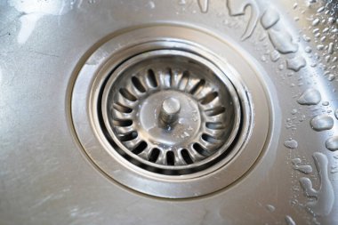 Paslanmaz çelik lavabo ve su modern bir mutfakta akıyor. Mutfak lavabosunda su akıyor. Su kanalizasyondan akıyor.