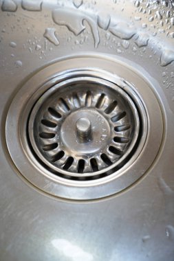 Stainless steel sink and water drain in a modern kitchen, water flow in the kitchen sink, water goes from the drain clipart