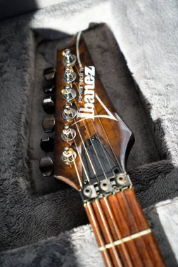 Close-up of ibanez electric guitar steel strings headstock and fretboard made of rosewood rest on a plush guard, Istanbul Turkey April 10 2024 clipart
