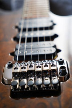 Elektro gitar köprüsü, teller ve pikap, ahşap cevizli gitar pikabının detaylı görüntüsü, telli müzik aleti.