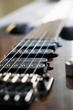 Elektro gitar köprüsü, teller ve pikap, ahşap cevizli gitar pikabının detaylı görüntüsü, telli müzik aleti.