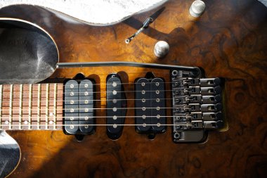 Elektro gitar köprüsü, teller ve pikap, ahşap cevizli gitar pikabının detaylı görüntüsü, telli müzik aleti.