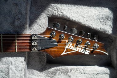 Close-up of ibanez electric guitar steel strings headstock and fretboard made of rosewood rest on a plush guard, Istanbul Turkey April 10 2024 clipart