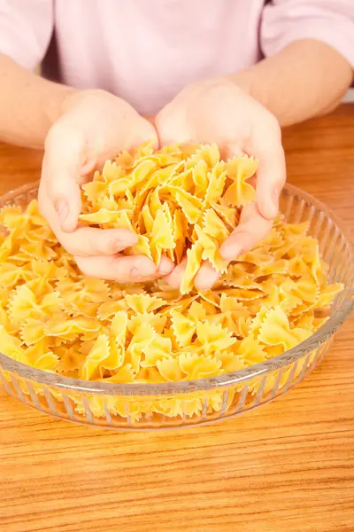 Stock image Uncooked raw healthy and delicious pasta macaroni held by a Caucasian man in glass plate on wooden table