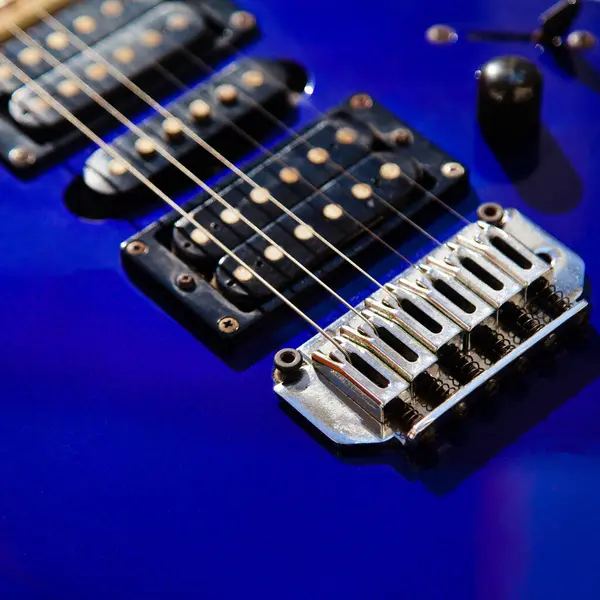 stock image Electric guitar bridge, strings and pickup, detail close-up view of guitar pickup in wood paint blue, stringed musical instrument