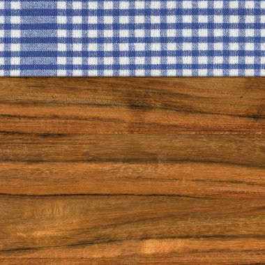 Ceviz ağacından yapılmış, mavi beyaz bir peçete boş bir masa ya da kesme tahtası.