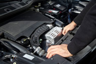 Beyaz bir araba tamircisinin elleri, arabanın motor bölmesinde genel bir kontrol yapılır. Araba bakım ve onarım işleri