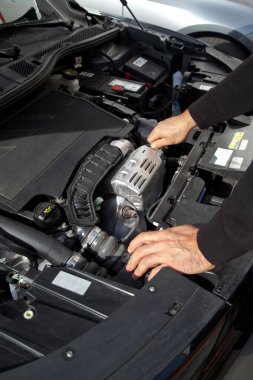 Beyaz bir araba tamircisinin elleri, arabanın motor bölmesinde genel bir kontrol yapılır. Araba bakım ve onarım işleri