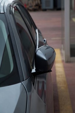 2024 yapımı çok lüks gri sedan model bir arabanın yan görüntüsü, katlanan ayna detayları.