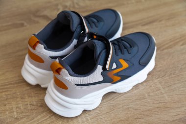 Yeni şık ve kullanışlı gri ya da mavi turuncu spor ayakkabılar, meşe ağacından zeminde.