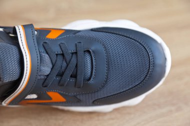 Yeni şık ve kullanışlı gri ya da mavi turuncu spor ayakkabılar, meşe ağacından zeminde.