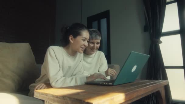两名年轻女子一边在家一起放松 一边在笔记本电脑上看有趣的视频 动作缓慢 — 图库视频影像