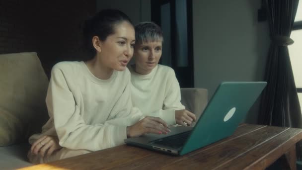 两名年轻女子一边在家一起放松 一边在笔记本电脑上看有趣的视频 动作缓慢 — 图库视频影像