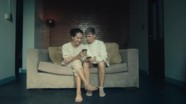 Két Fiatal Otthon Telefonjával Kanapén Lassított Felvételen — Stock videók