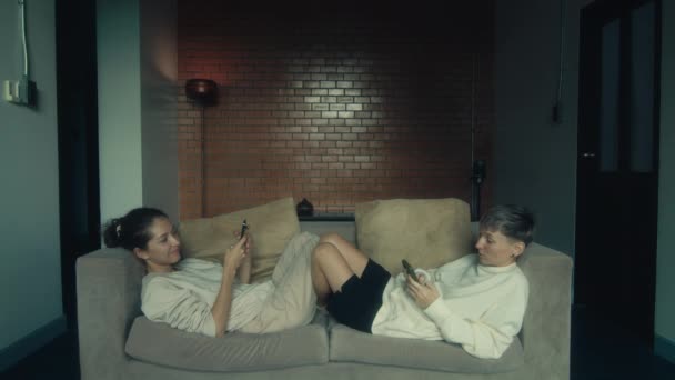 Duas Jovens Mulheres Sentadas Com Seus Telefones Sofá Sua Casa — Vídeo de Stock