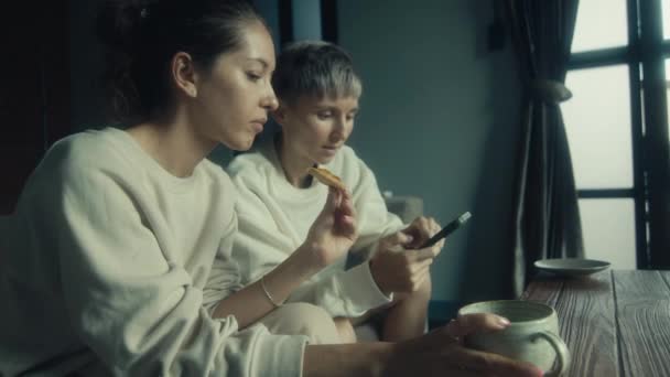 Twee Jonge Vrouwen Met Hun Telefoon Bank Hun Huis Slow — Stockvideo