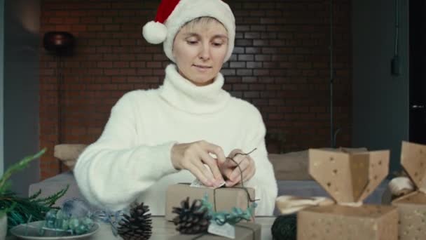 年轻女子为她的朋友和亲戚打包圣诞礼物 而女性则紧紧抓住包装圣诞礼物的手 圣诞装饰品 为节日作准备 — 图库视频影像