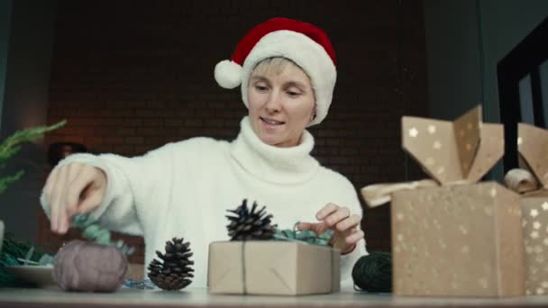 彼女の友人や親戚のためのクリスマスの贈り物を詰め若い女性 クリスマスの贈り物を詰め女性の手の閉じる クリスマスの装飾 お祝いの季節の準備 — ストック動画