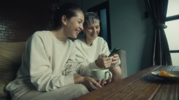 Duas Jovens Mulheres Assistindo Vídeos Engraçados Seu Smartphone Enquanto Relaxam — Vídeo de Stock