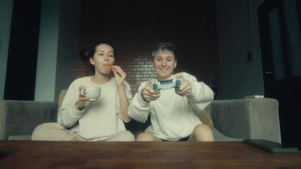 Δύο Νεαρές Γυναίκες Παίζουν Ένα Βιντεοπαιχνίδι Στον Καναπέ Στο Σπίτι — Αρχείο Βίντεο