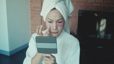 Young asian transgender queer man does his makeup in his room while getting ready for a date