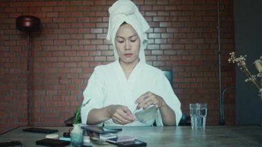 Young asian transgender queer man does his makeup in his room while getting ready for a date
