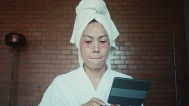 Young asian transgender queer man does his makeup in his room while getting ready for a date