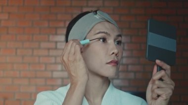 Young asian transgender queer man does his makeup in his room while getting ready for a date